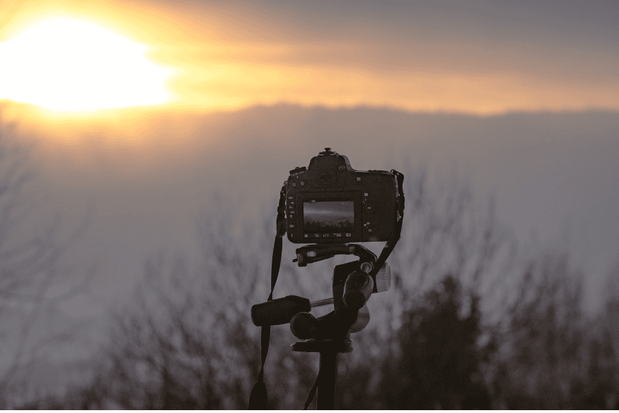 Câmera no tripé com forte luz no horizonte, situação que pode gerar erros comuns ao praticar astrofotografia de longa exposição.