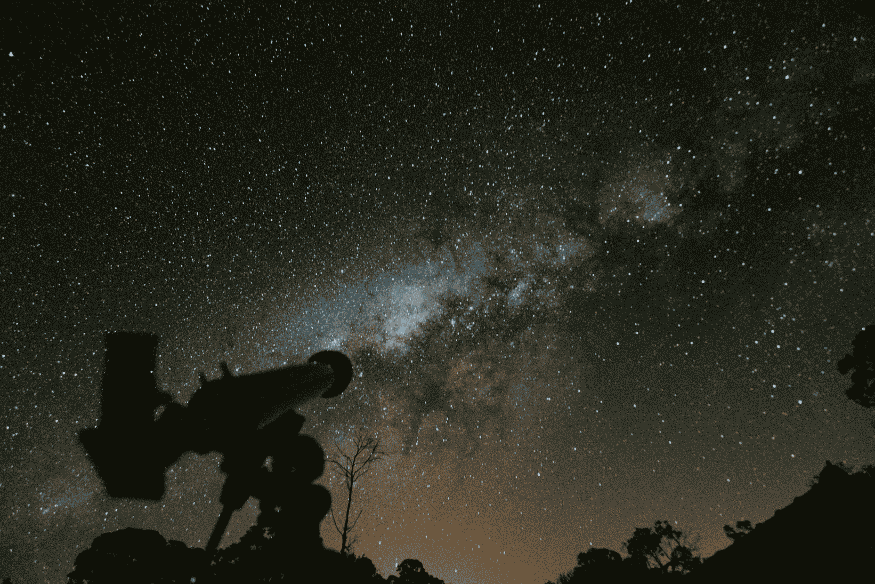 Silhueta de telescópio diante da Via Láctea, exemplo de composição usada em astrofotografia de longa exposição.