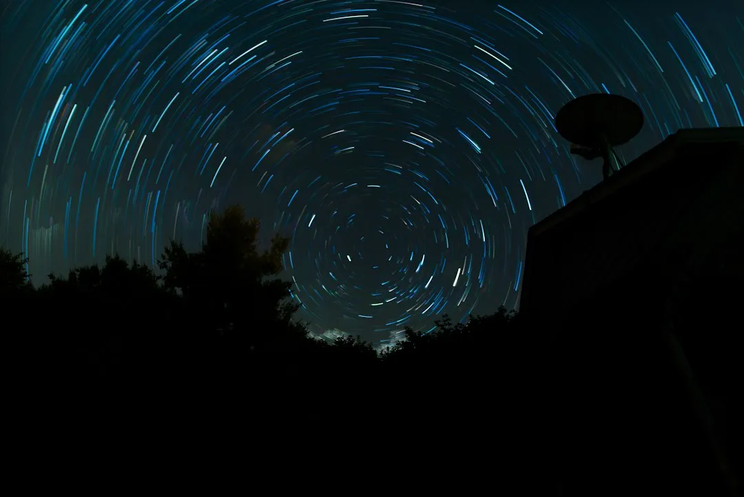 Astrofotógrafo amador com telescópio no quintal durante a noite