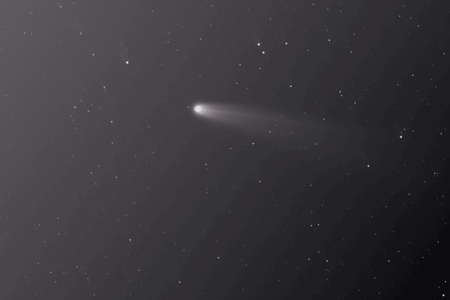 Céu estrelado com objeto brilhante e cauda luminosa, imagem ilustrativa de meteoro durante uma chuva de meteoros.