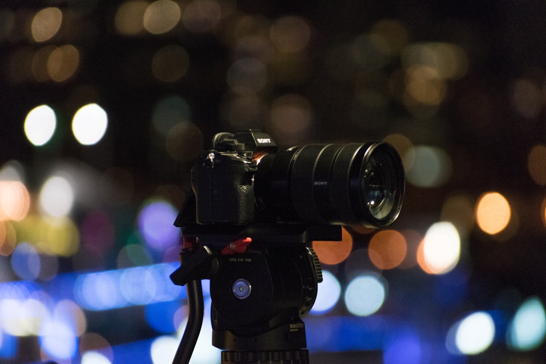 Câmera em tripé fotografando lua durante eclipse