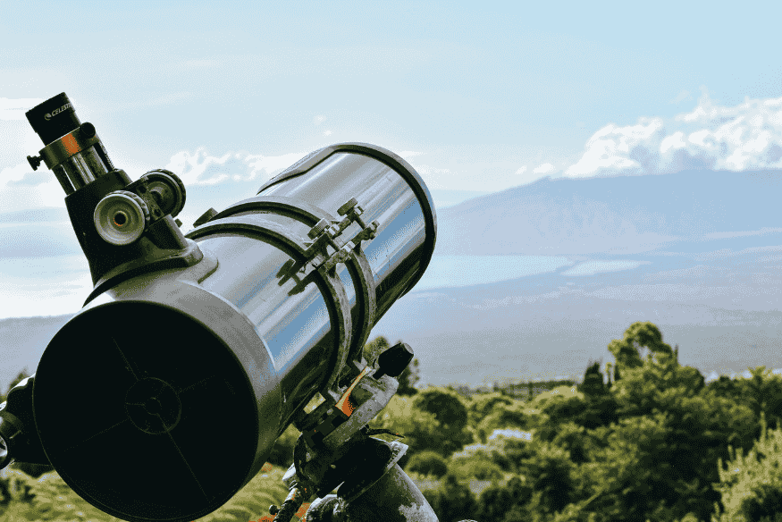 Telescópio refrator em área aberta, destacando a importância do diâmetro da lente na entrada de luz e na qualidade da observação.