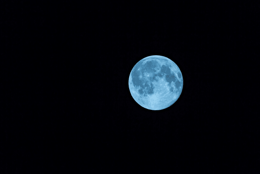 Lua cheia com tonalidade azul em fundo preto, usada para ilustrar o significado de “Lua Azul”.