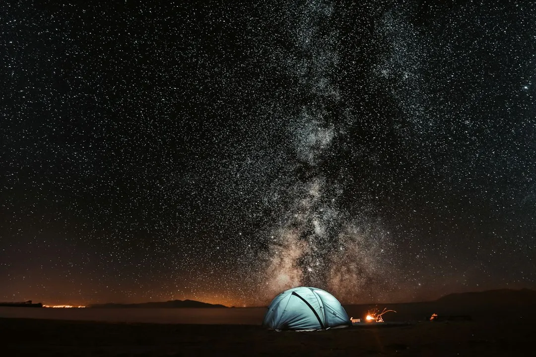 Pessoas observando o céu estrelado em local afastado das luzes da cidade