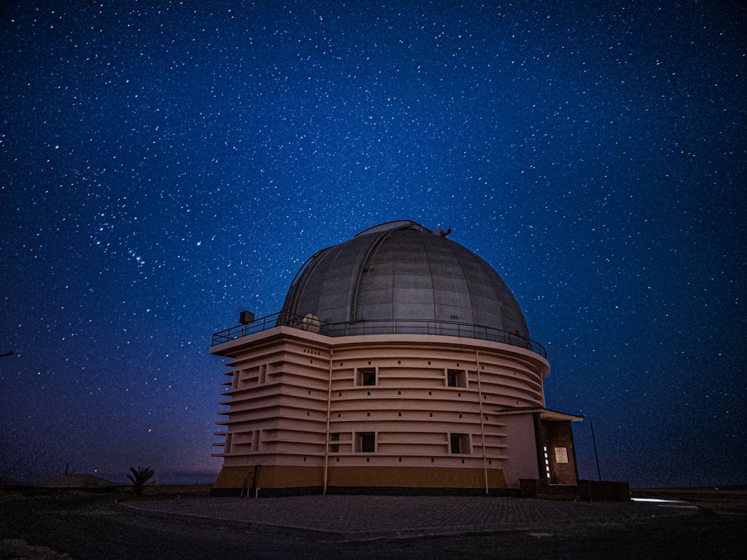 Telescopio de observatorio apontado para o ceu estrelado durante a noite