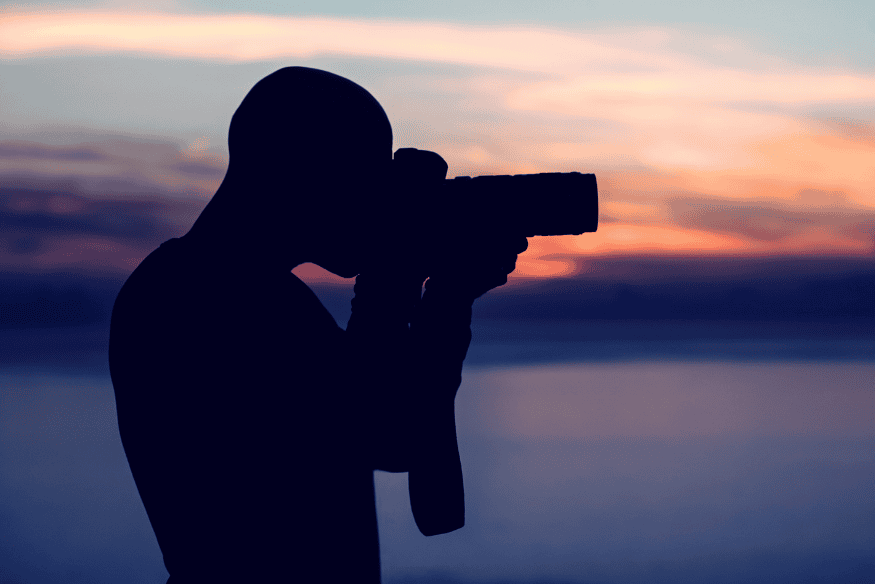 Silhueta de fotógrafo com câmera ao entardecer, prática de treino para registrar conjunções planetárias com melhor timing e enquadramento.