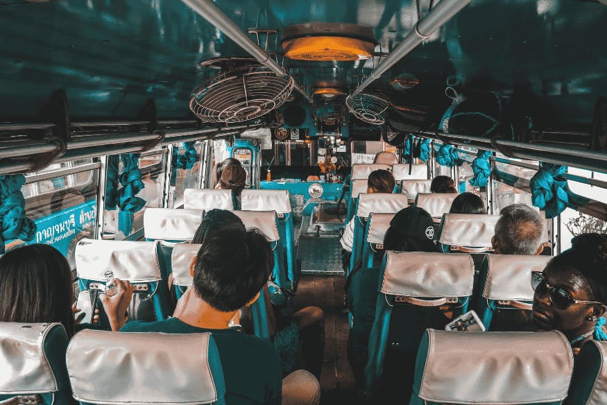 Interior de ônibus com passageiros, representando o deslocamento e a logística de viagens para observação astronômica.