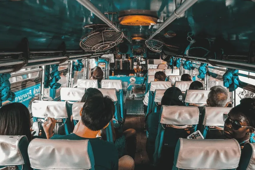 Interior de ônibus com passageiros, representando o deslocamento e a logística de viagens para observação astronômica.