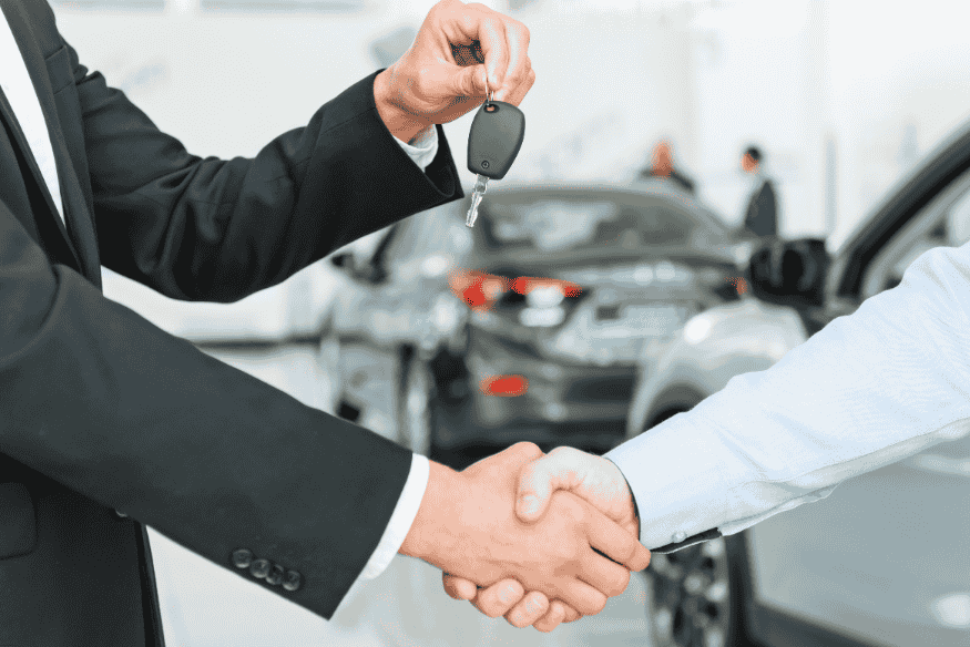 Pessoa recebendo a chave do carro alugado após fechar contrato