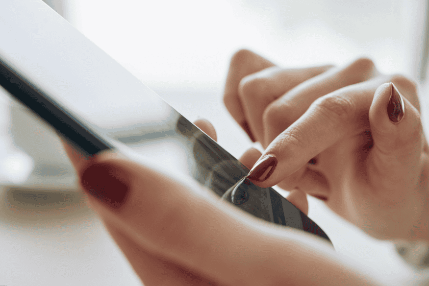 Mãos femininas usando smartphone com tela sensível ao toque.