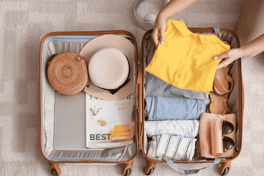 Mala de viagem sendo organizada com roupas e acessórios