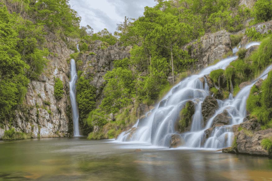 Duas quedas d’água com poço natural cercado por vegetação na Chapada dos Veadeiros