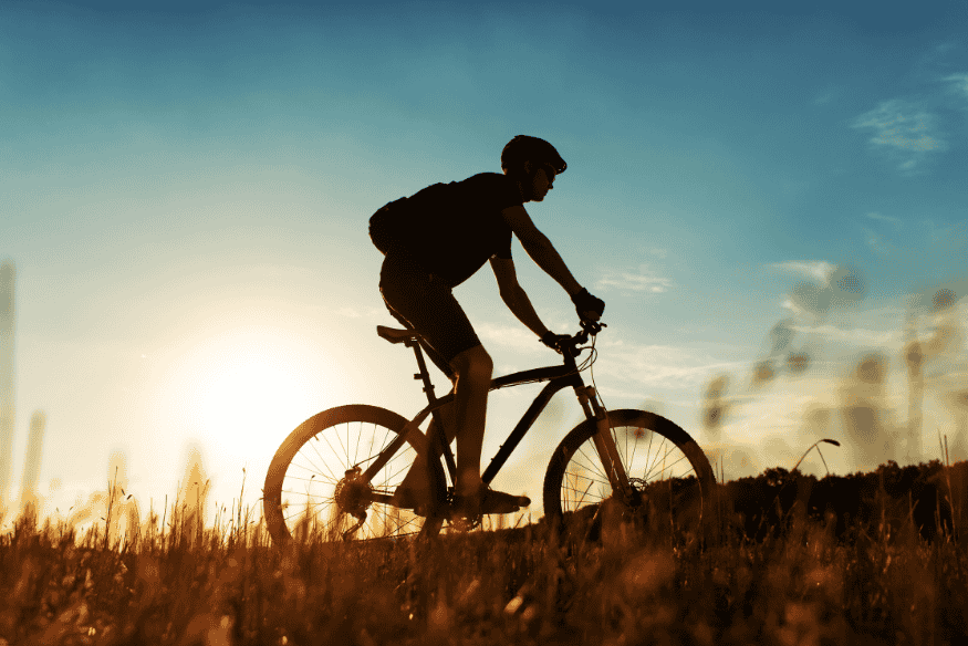 Ciclista pedalando em trilha ao entardecer no Vale Europeu, Brasil.