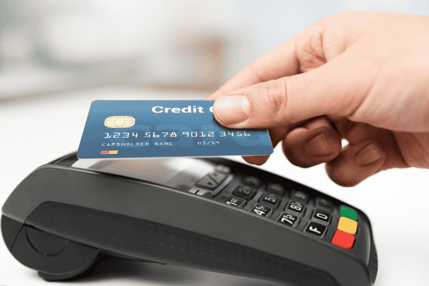 Pessoa passando cartão de crédito em uma maquininha de pagamento