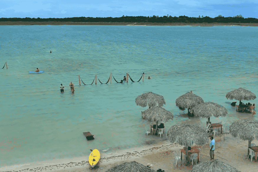 Lagoa em Jericoacoara com redes na água e barracas de palha na areia