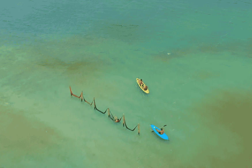 Pessoas relaxando em redes dentro da água azul-turquesa em Jericoacoara