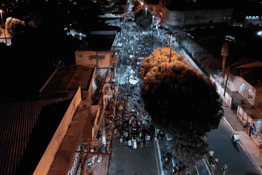 Vista aérea noturna de uma multidão reunida nas ruas de Parintins durante o festival folclórico.