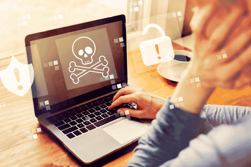 Pessoa usando notebook com alerta de vírus na tela.