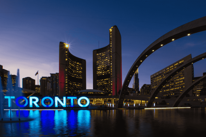 Vista noturna da praça Nathan Phillips Square com o letreiro iluminado de Toronto