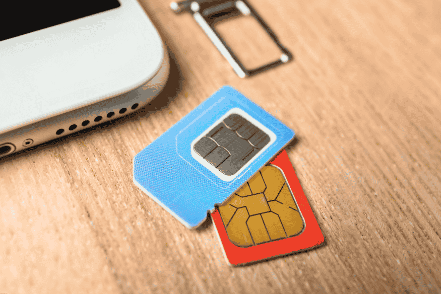 Chips SIM sobre mesa ao lado de smartphone.