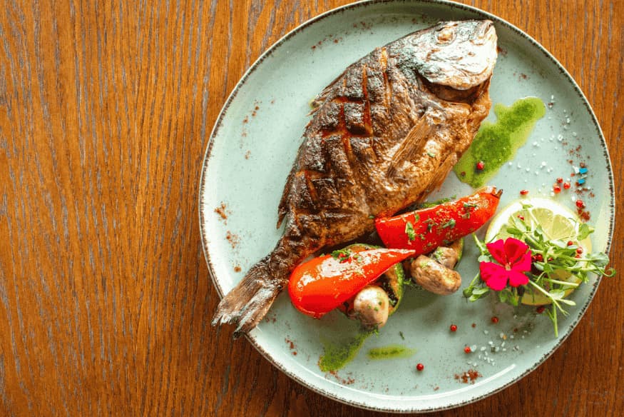 Prato típico português com peixe grelhado, pimentão, cogumelos e ervas