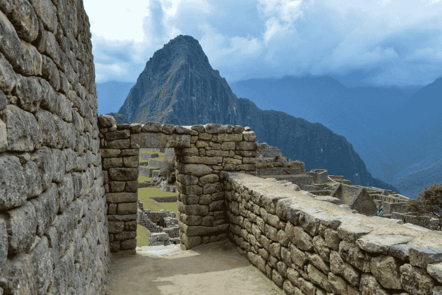 Estrutura de pedra em Machu Picchu com vista para a montanha Huayna Picchu ao fundo