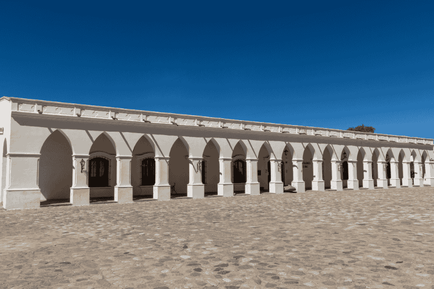 Fachada do Museo Arqueológico Pío Pablo Díaz em Cachi, Argentina, com colunas brancas e céu azul ao fundo.