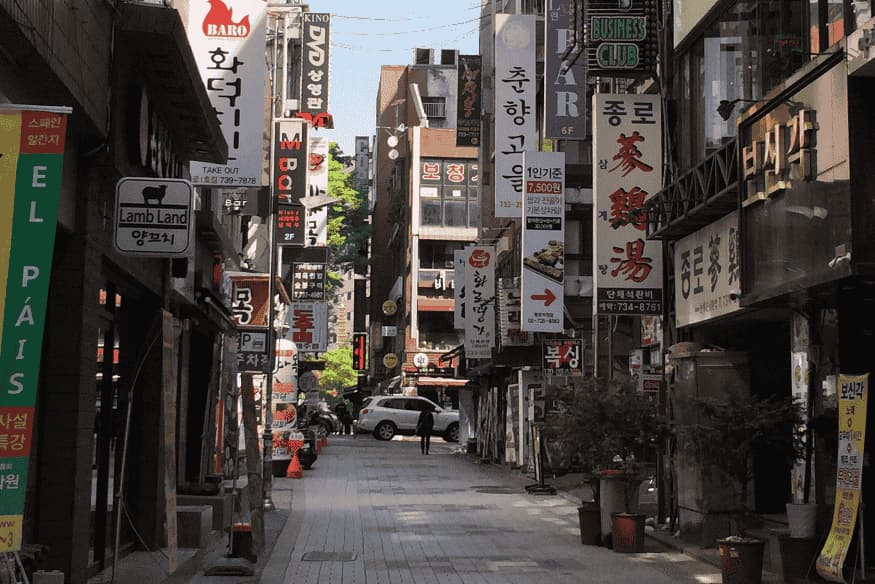 Rua típica de Seul com letreiros em coreano e restaurantes tradicionais nas laterais