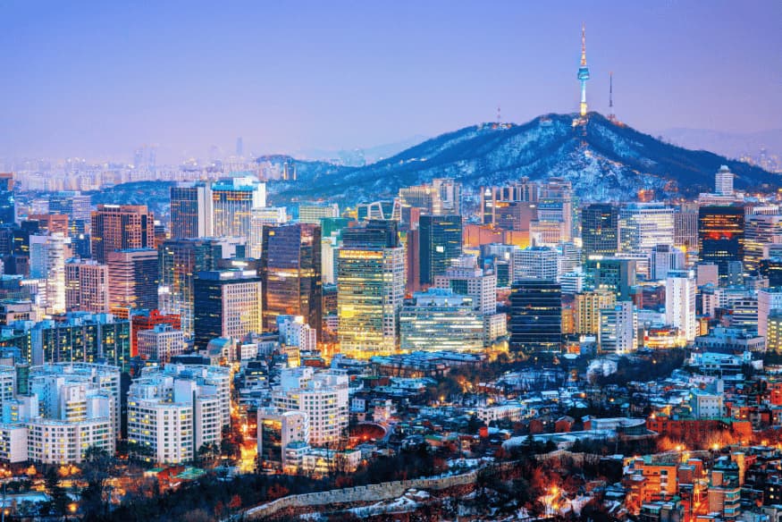 Vista panorâmica de Seul ao entardecer com a Torre Namsan iluminada ao fundo