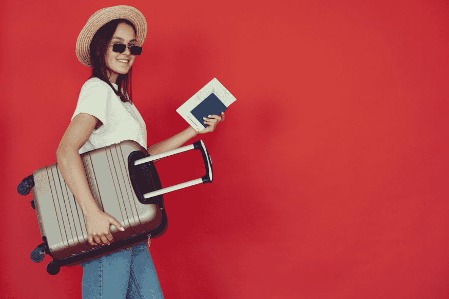 Mulher sorridente com mala e passaporte sobre fundo vermelho