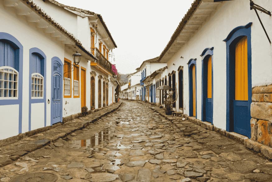 Rua de paralelepípedo no centro histórico de Paraty com fachadas azuis e amarelas
