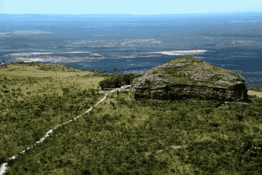 Morro rochoso cercado por vegetação no Parque Nacional da Chapada dos Guimarães.