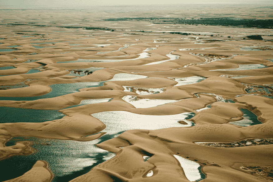 Vista aérea dos Lençóis Maranhenses com dunas e lagoas cristalinas no Maranhão.