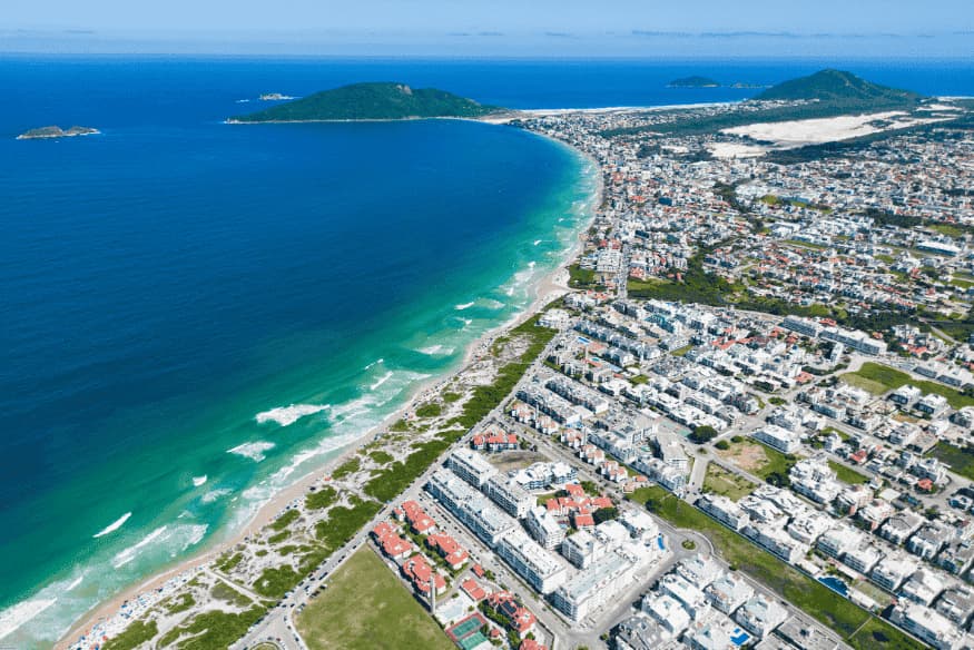 Vista aérea da Praia dos Ingleses com faixa de areia extensa e mar azul em Florianópolis.