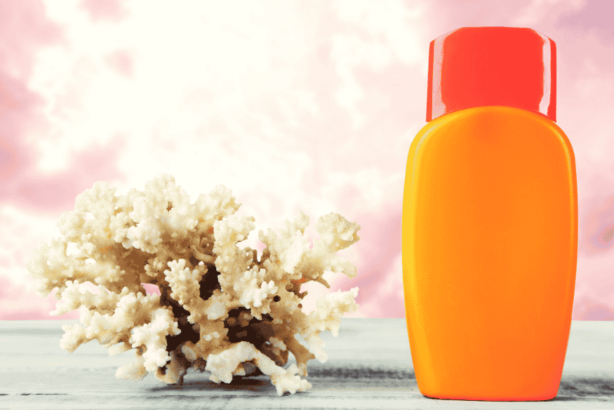 Protetor solar reef safe ao lado de coral em cenário tropical