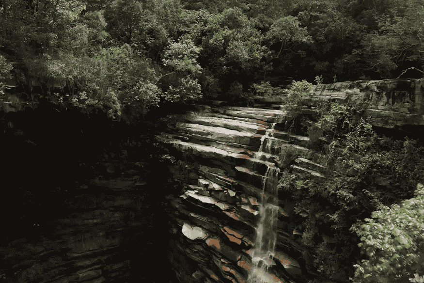 Cachoeira entre rochas e vegetação densa na Chapada Diamantina