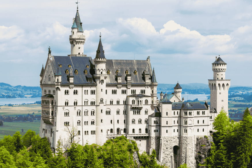 Castelo Neuschwanstein visto entre as árvores e colinas da Baviera, Alemanha.