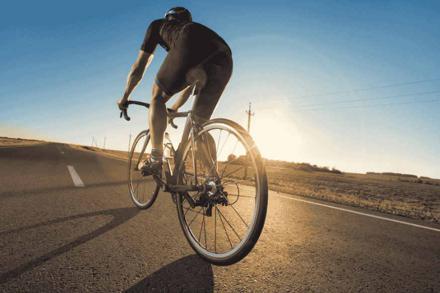 Ciclismo solo na Estrada Real em trecho de asfalto ao entardecer