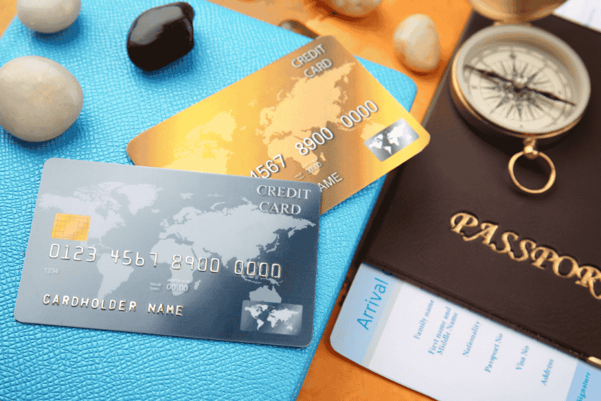Cartões de crédito e passaporte sobre mesa de viagem.