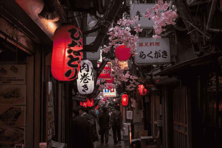 Ruelinhas estreitas de Tóquio decoradas com lanternas vermelhas e flores de cerejeira.