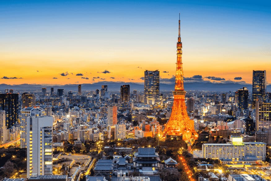 Vista panorâmica de Tóquio ao entardecer, com a Tokyo Tower iluminada ao centro.