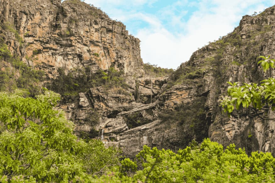 Paisagem de paredões rochosos e vegetação nativa na Serra do Cipó