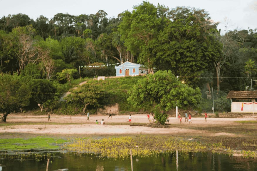 Crianças brincando de futebol em vila ribeirinha da Amazônia.