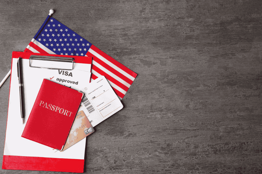 Passaporte, visto aprovado, cartão e bandeira dos EUA sobre superfície cinza