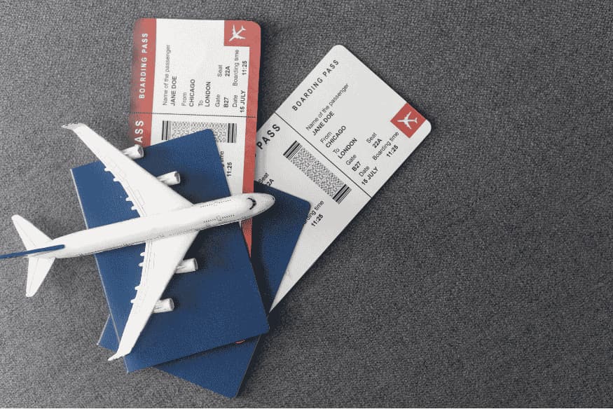 Passaportes, cartões de embarque e miniatura de avião simbolizando planejamento de passagens dentro do orçamento de viagem.