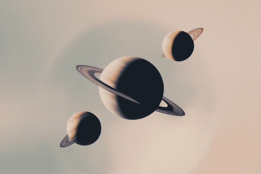 Planetas com anéis em composição espacial, ilustrando a proximidade aparente em uma conjunção planetária.