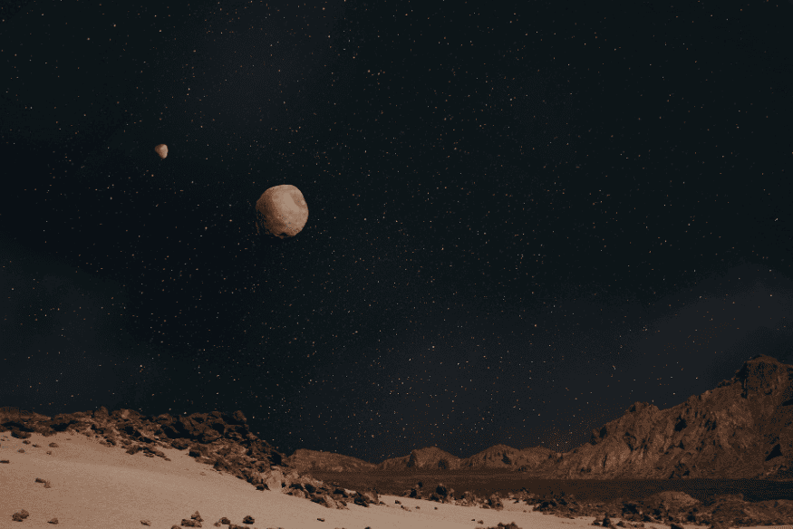 Céu noturno estrelado sobre paisagem rochosa com dois astros visíveis, cenário típico de observação de conjunções planetárias.