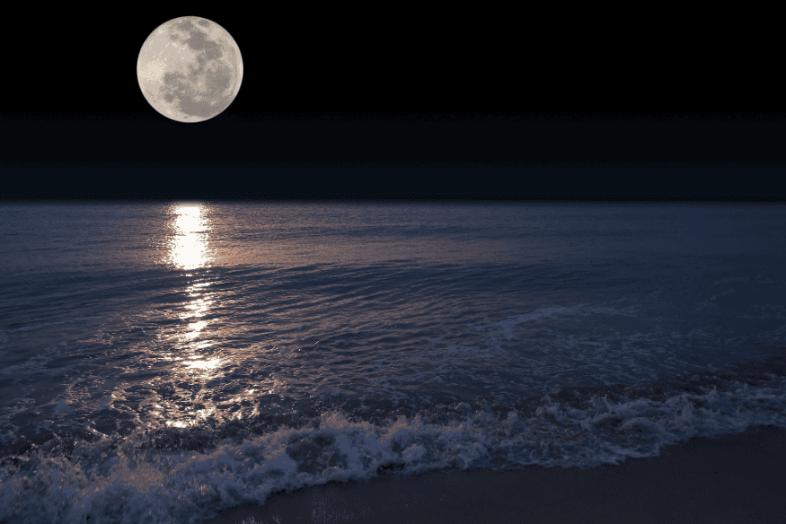 Superlua sobre o mar à noite com reflexo luminoso na água, ilustrando a influência da Lua nas marés.