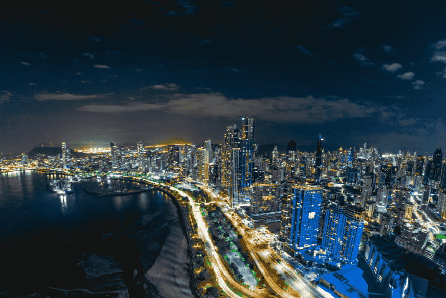 Vista aérea de cidade iluminada à noite mostrando forte poluição luminosa, um dos principais obstáculos para observar o céu urbano.