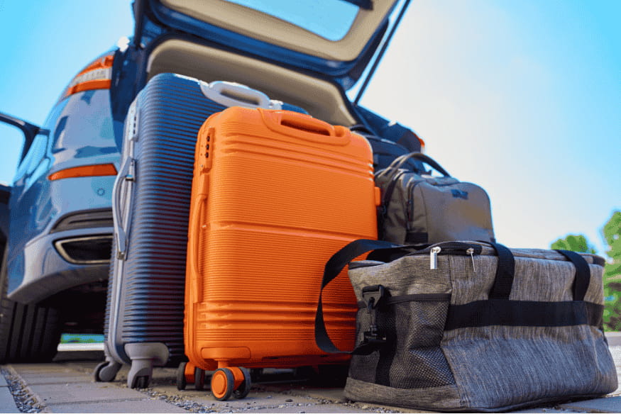 Mala e bolsas prontas ao lado de carro, itens essenciais para organizar uma viagem focada em observação astronômica.